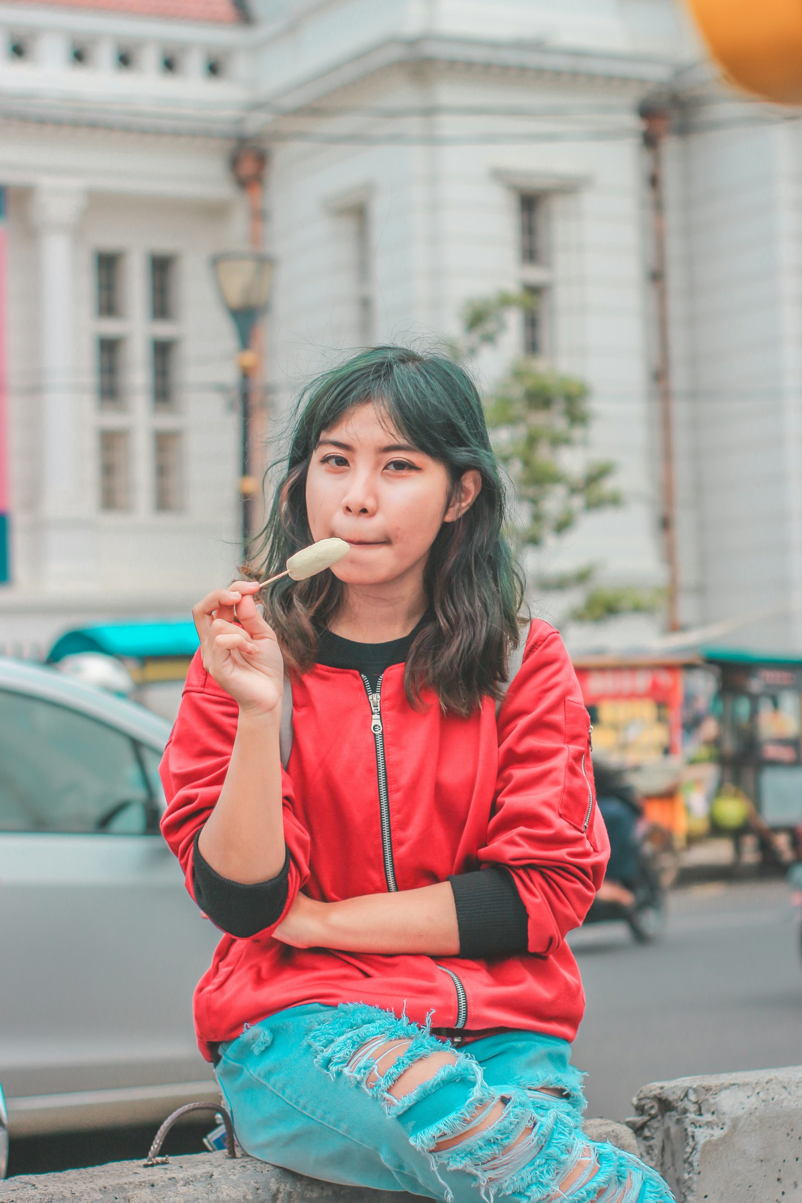 A Malaysian teenager eating a street snack outdoors